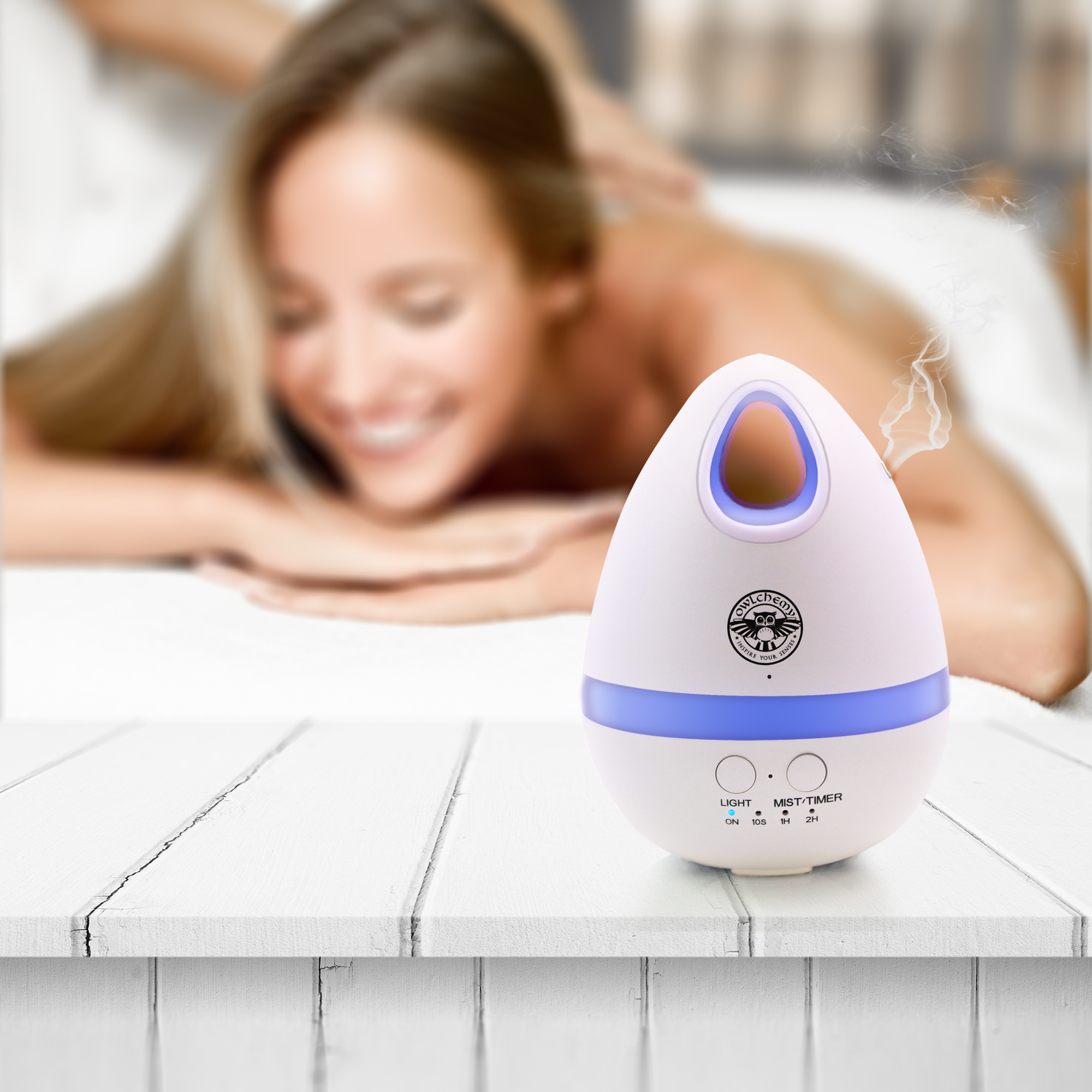 A woman laying on a bed behind our Electric Essential Oil Diffuser with Detox & Cleanse Essential Oils.
